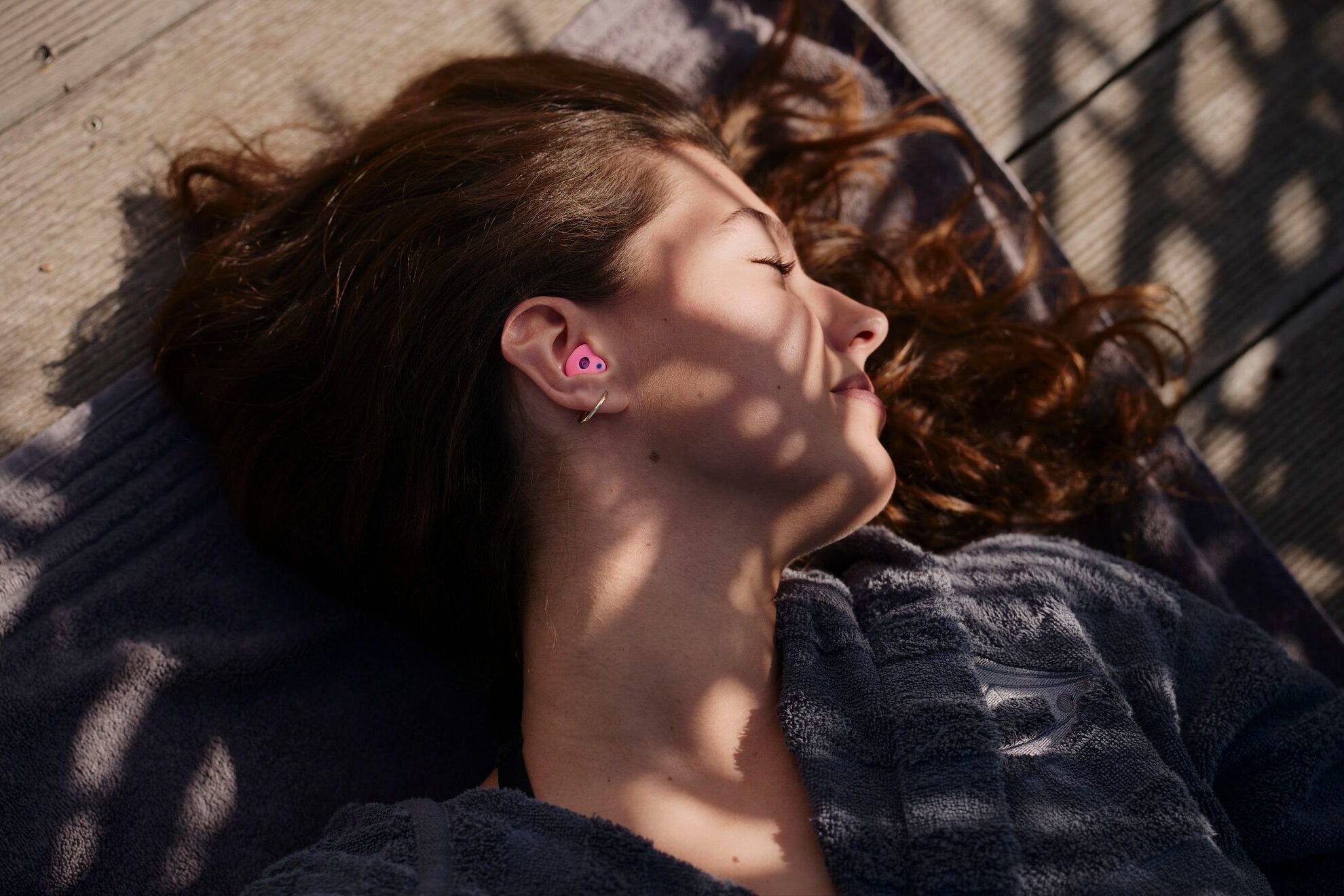 Frau entspannt in der Sonne mit individuell angepasstem Gehörschutz aus Silikon mit Filter – Maßgefertigter Gehörschutz für optimalen Komfort und effektive Geräuschreduzierung in jeder Umgebung